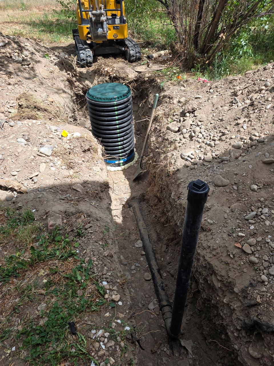 Excavated trench with a newly installed sewer line and riser